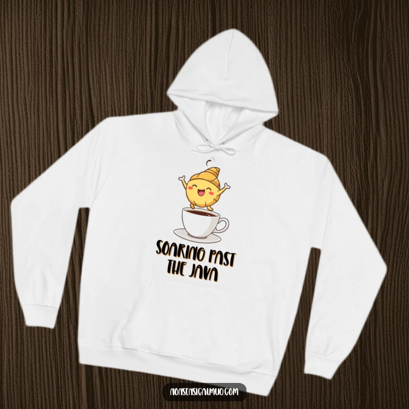 Funny croissant character leaping energetically over a coffee cup, depicted on a comfortable hoodie for a cozy, humorous feel.
